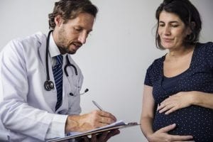 Pregnant woman having fetal monitoring by doctor